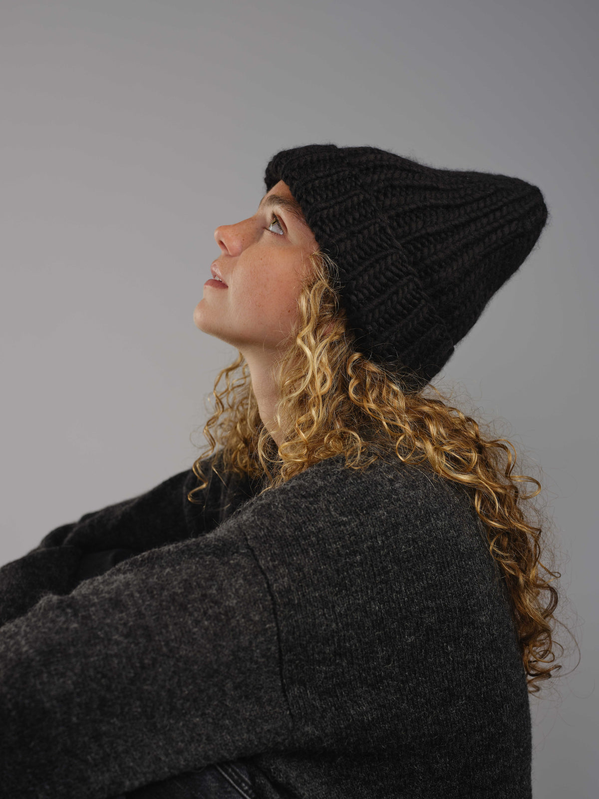 The Workwear merino beanie in Ink, worn — alternate view