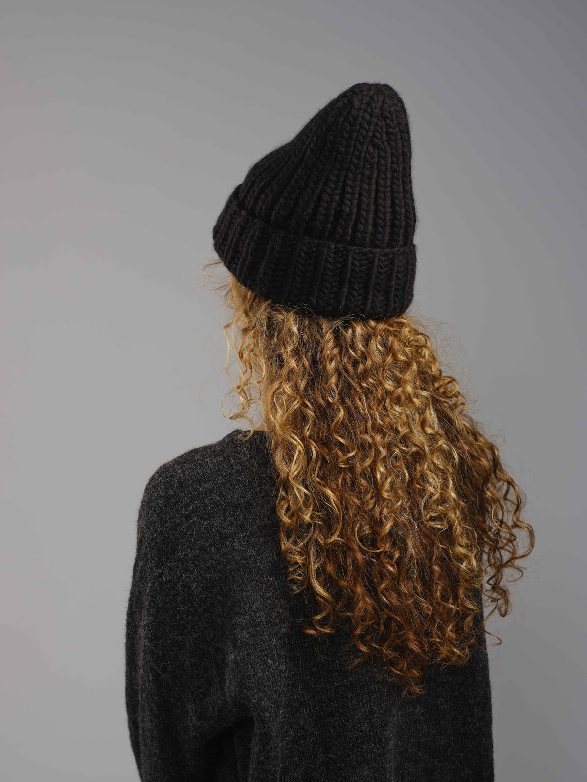 The Workwear merino beanie in Ink, worn — alternate view