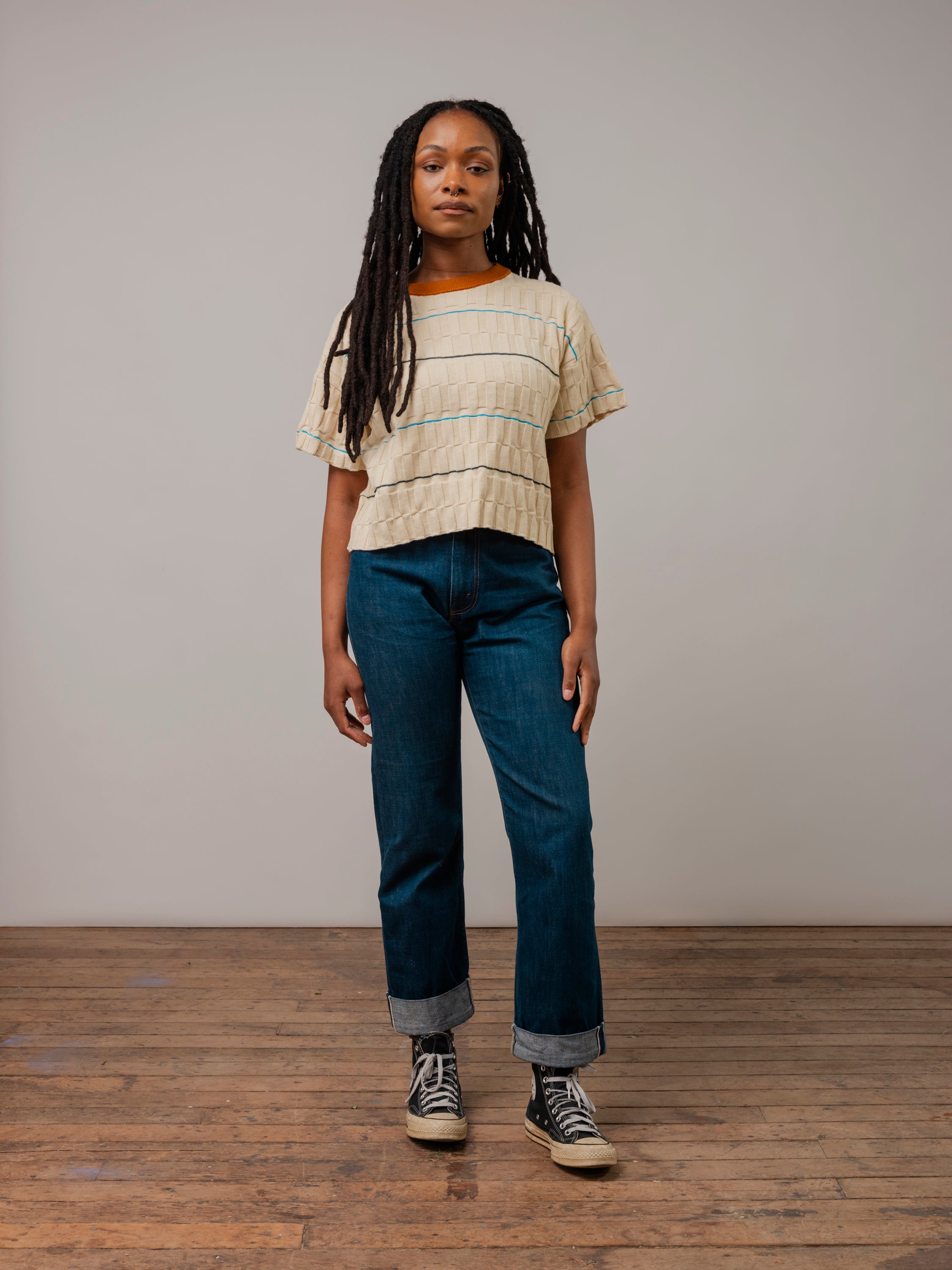 The Wiggle Stripe Knit Grid Tee paired with jeans and converse, perfect for everyday ethical fashion.