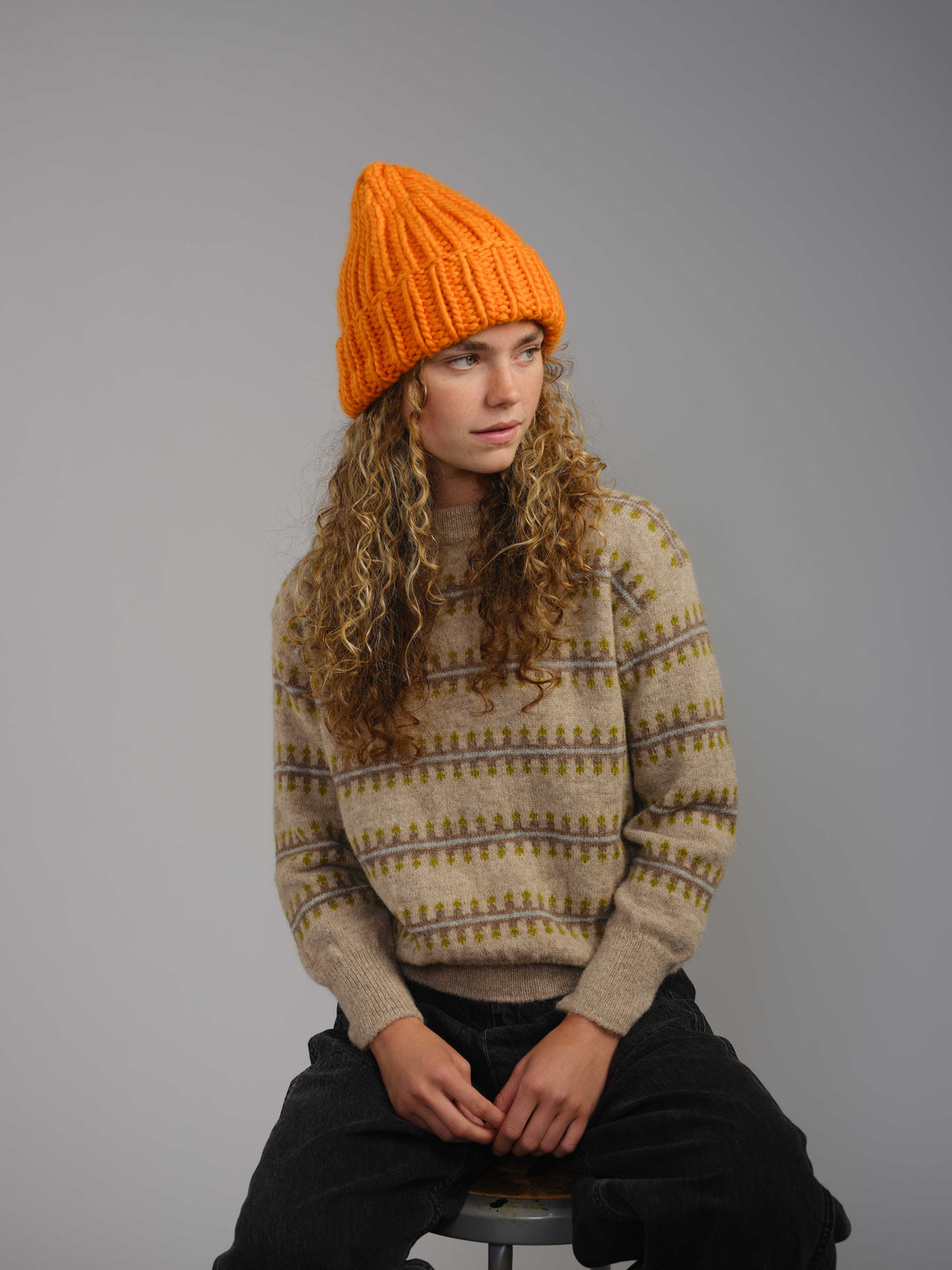 The Workwear hand-knit merino wool beanie in Persimmon, worn