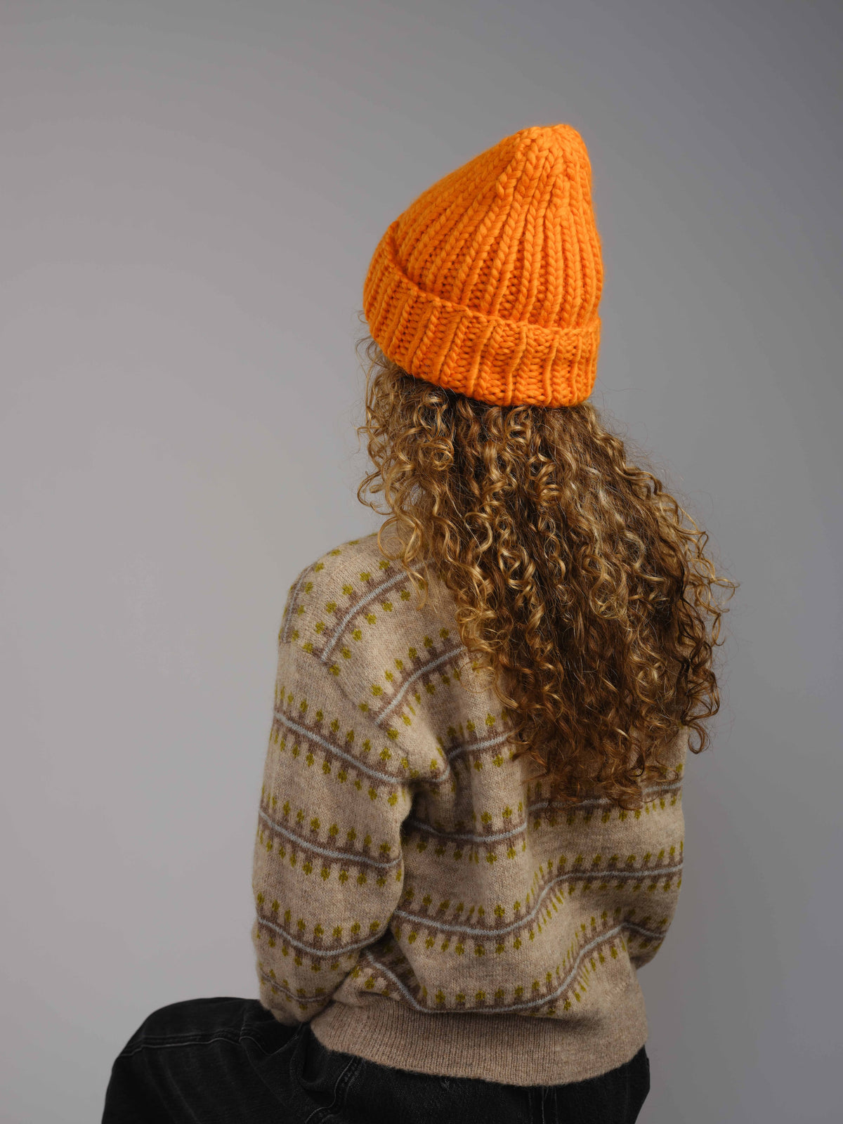The Workwear merino beanie in Persimmon, worn — alternate view