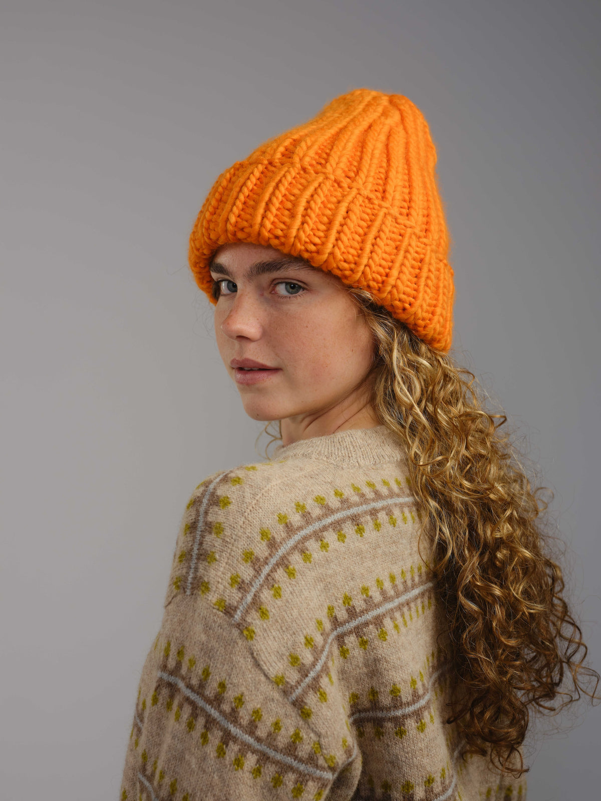 The Workwear merino beanie in Persimmon, worn — alternate view