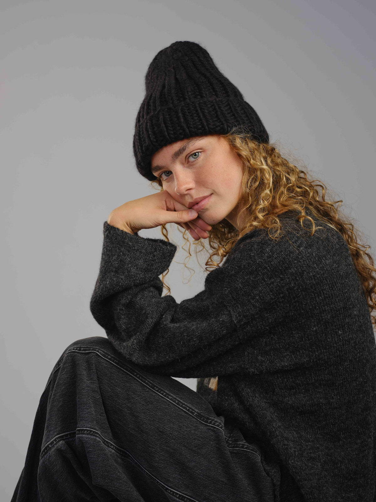 The Workwear hand-knit merino wool beanie in Ink, worn