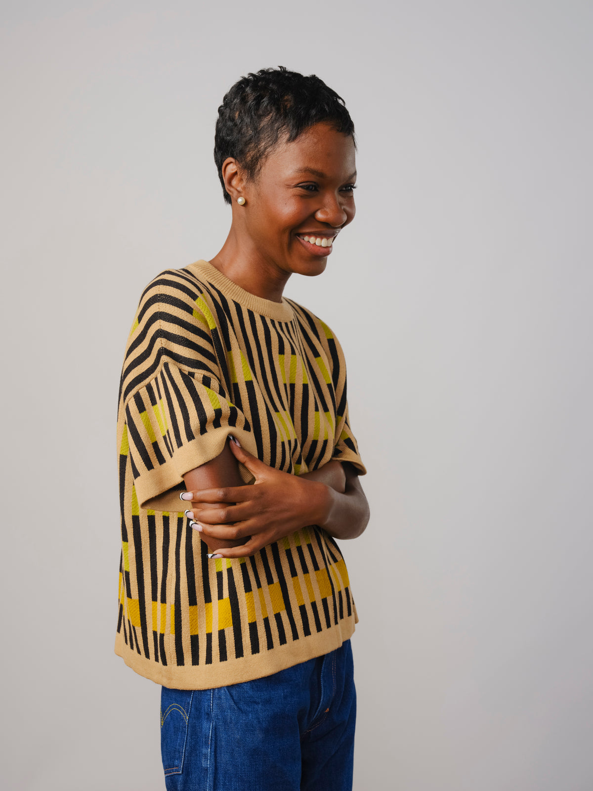 Smiling woman in a black and yellow patterned Endery knit tee